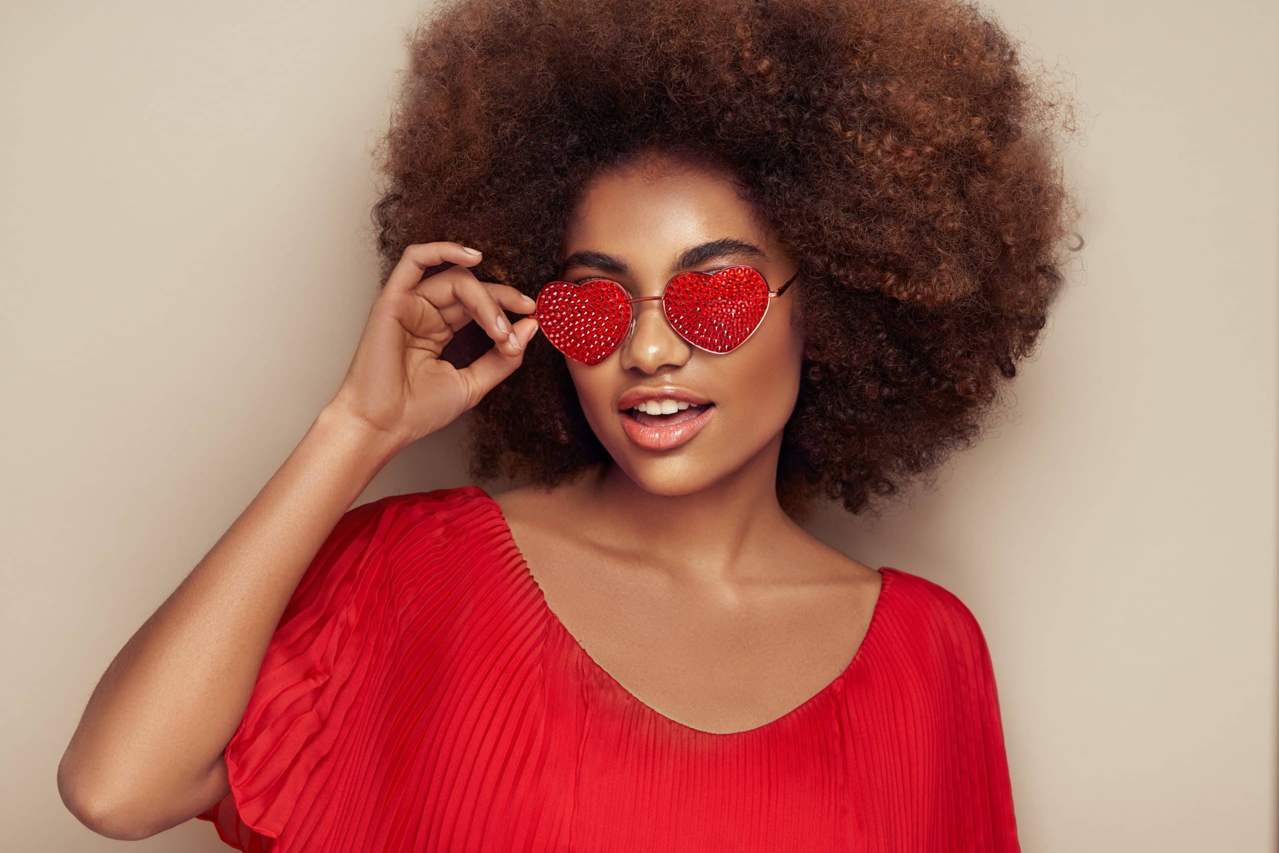 Beautiful portrait of an African girl in sunglasses in the shape of hearts