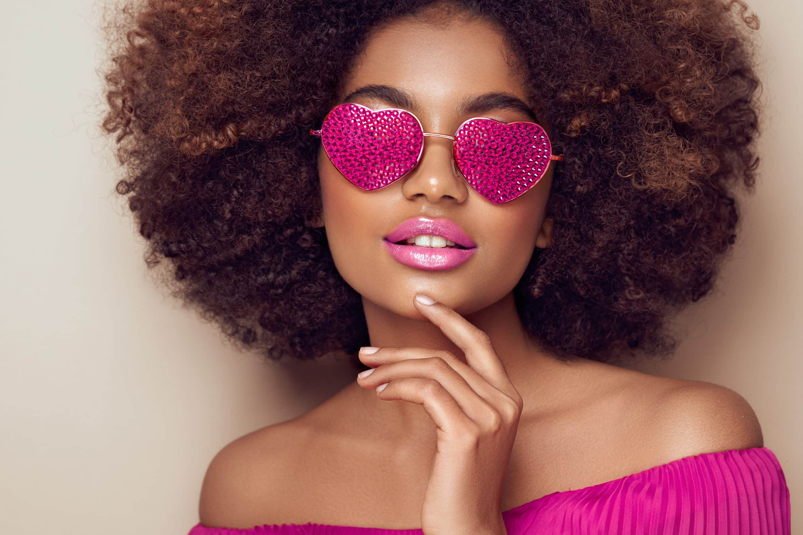 Beautiful portrait of an African girl in sunglasses in the shape of hearts